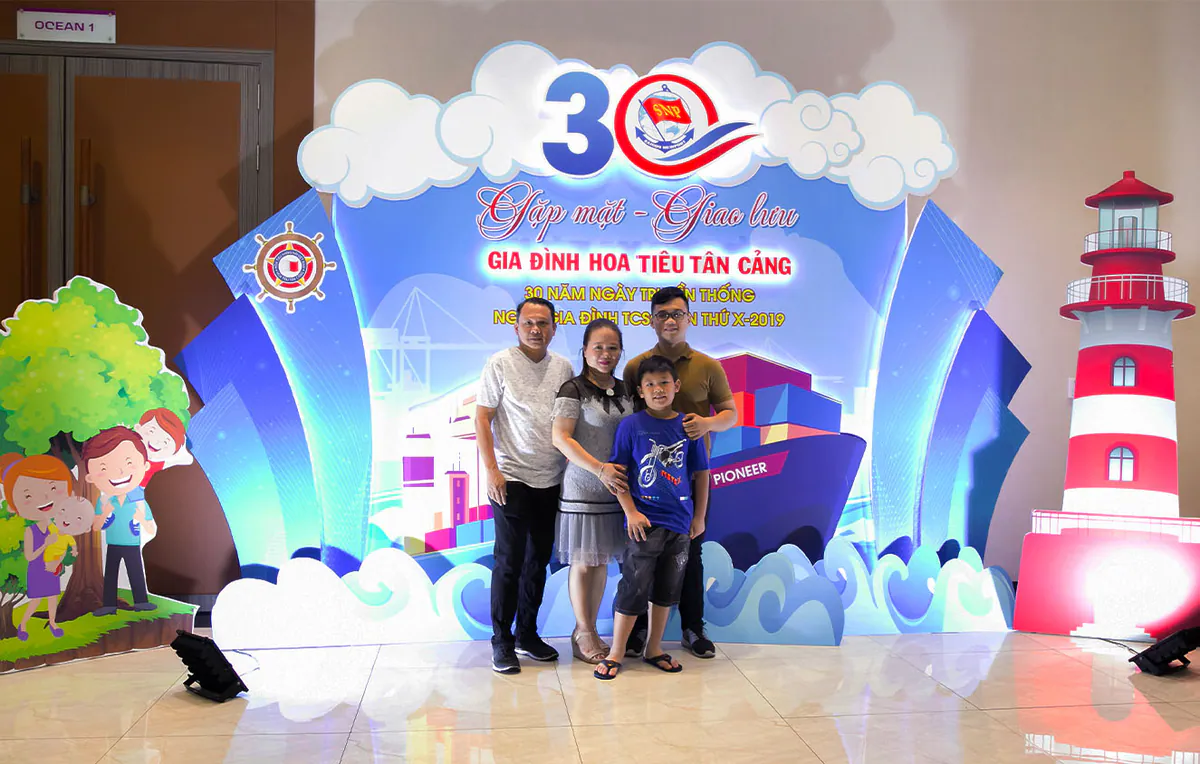 Gia đình chụp ảnh trước backdrop Gặp mặt Giao lưu Gia đình Hoa Tiêu Tân Cảng kỷ niệm 30 năm