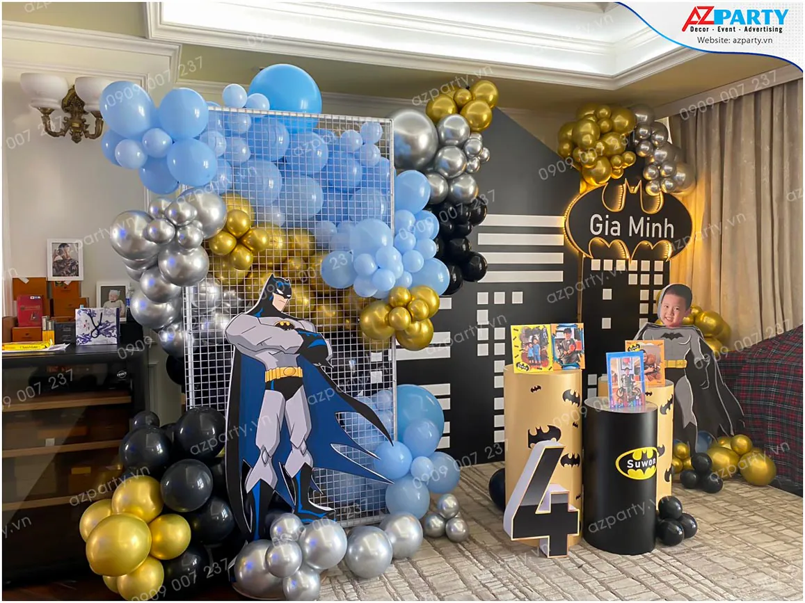 Khu vực check-in tiệc sinh nhật bé Gia Minh được trang trí lưới sắt trắng đan xen bong bóng nghệ thuật và standee Batman dũng cảm.