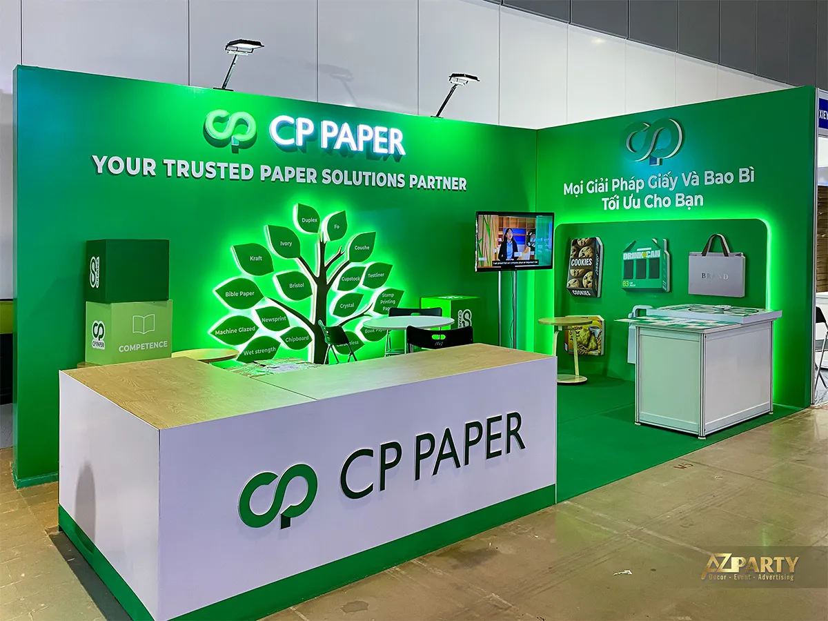Góc nghiêng gian hàng CP PAPER làm rõ quầy lễ tân chữ L và cây danh mục giấy phát sáng