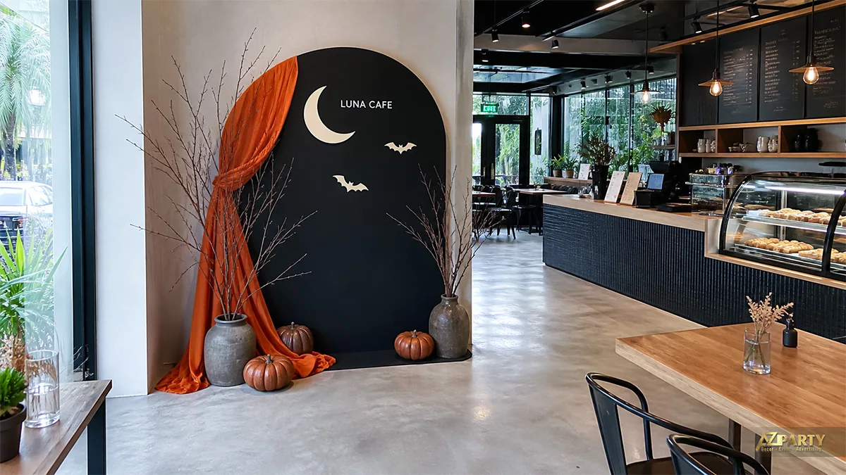 Góc check-in Luna Cafe với nền vòm đen, rèm cam, trăng khuyết và bí ngô
