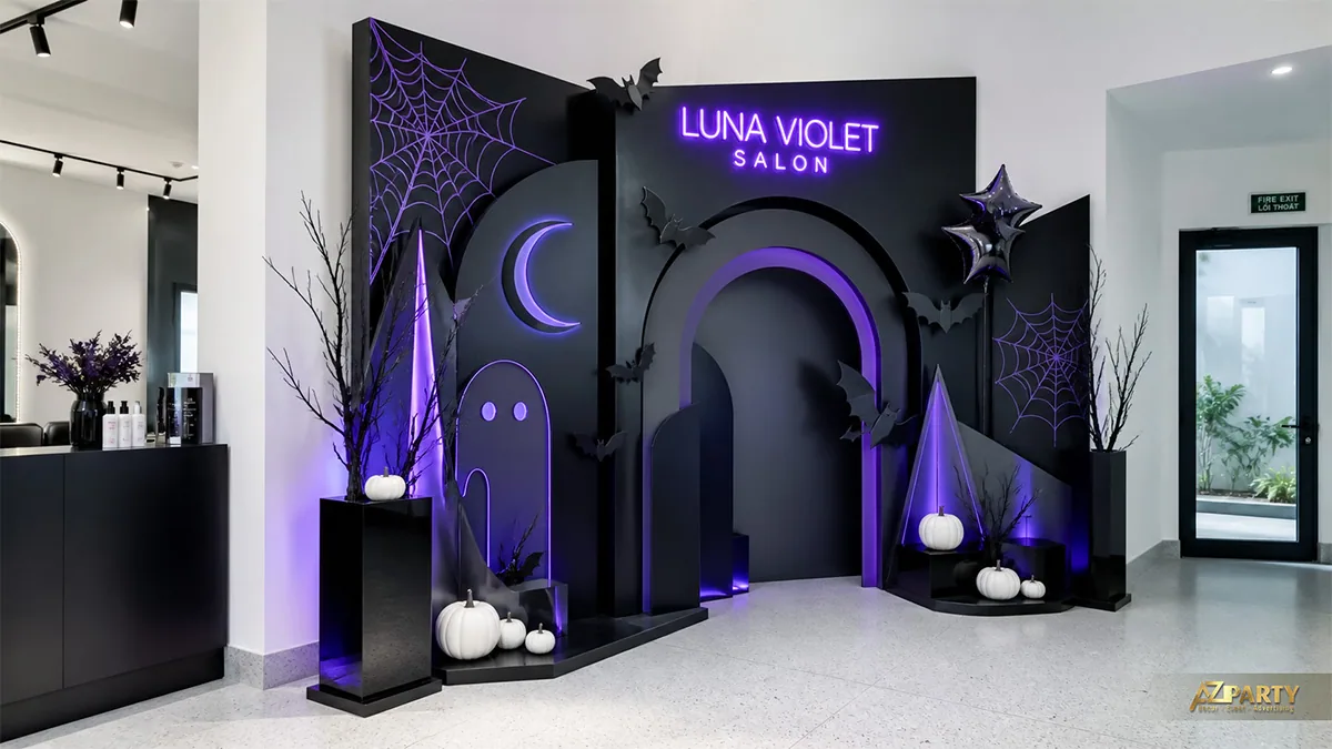 Góc check-in salon Halloween màu đen tím với vòm cong, mạng nhện và bí ngô trắng