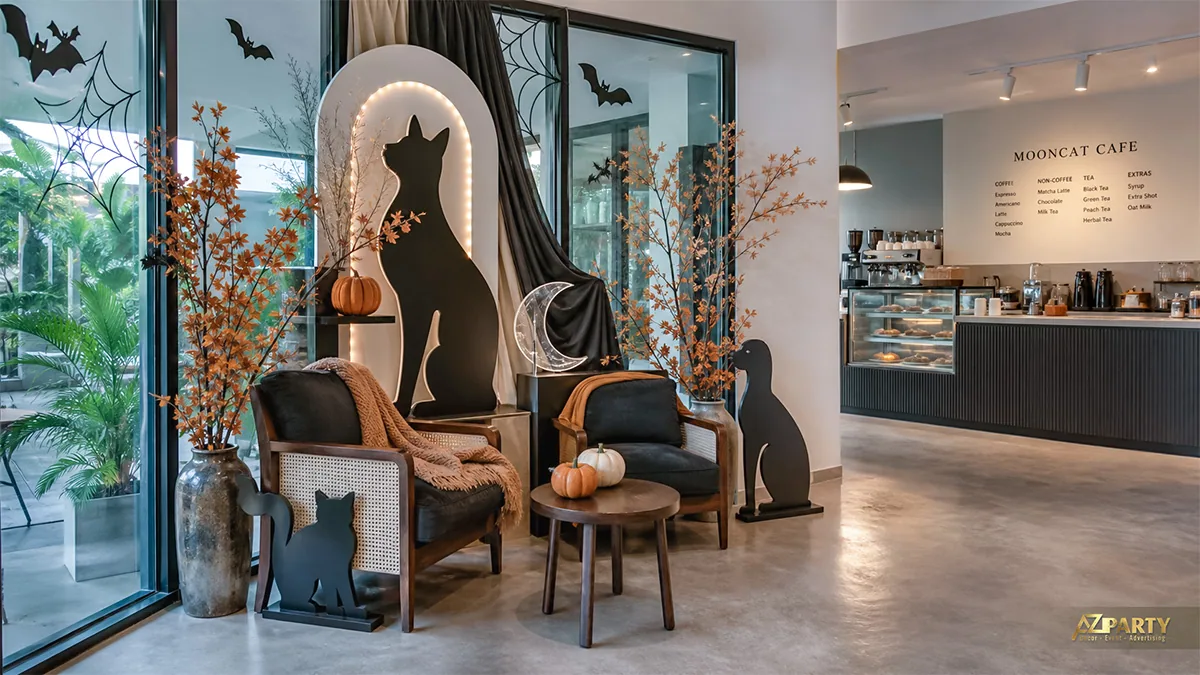 Góc lounge Mooncat Cafe với mèo đen, lá cam, bí ngô và hốc vòm phát sáng