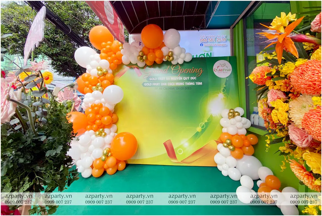 Backdrop khai trương cửa hàng Gold Fruit Sài Gòn trang trí bong bóng tông cam trắng nổi bật
