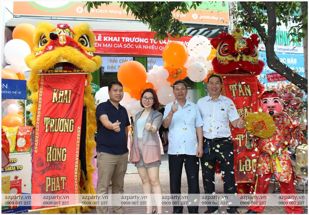 Khách mời chụp ảnh lưu niệm cùng cặp lân đỏ vàng trong cơn mưa pháo hoa giấy khai trương Gold Fruit