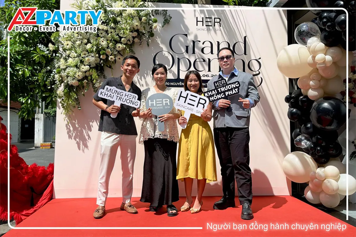 Khách mời rạng rỡ check-in tại backdrop khai trương HER Skincare Spa Quận Bình Thạnh.