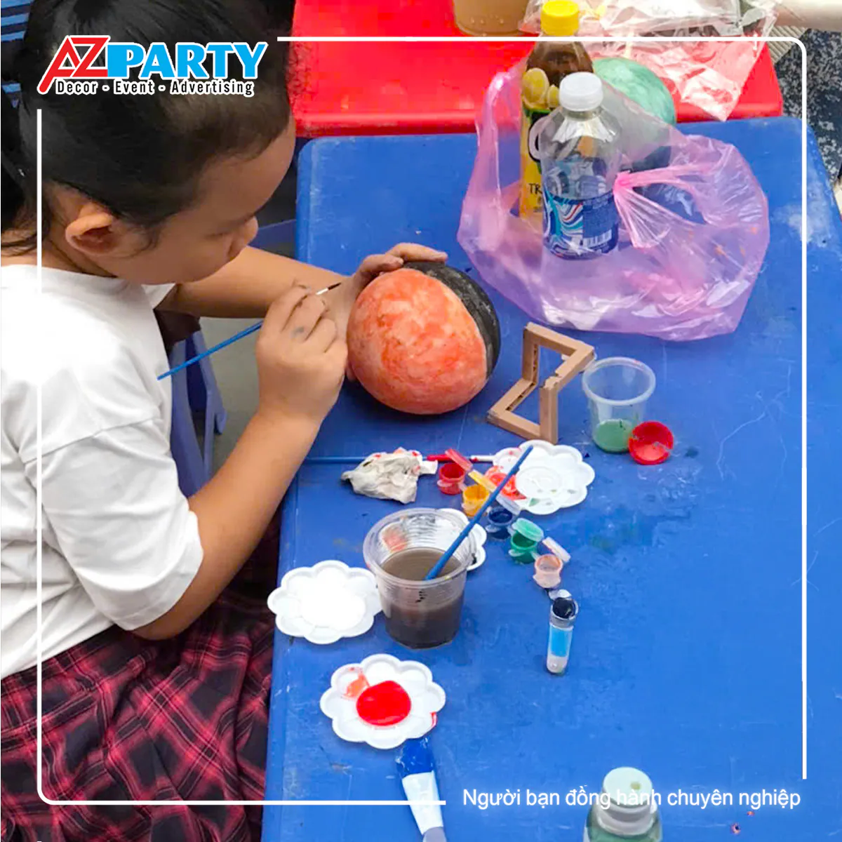 Bé gái tô màu tượng thạch cao hình tròn trên bàn xanh tại Đêm hội Trung Thu Waterpoint