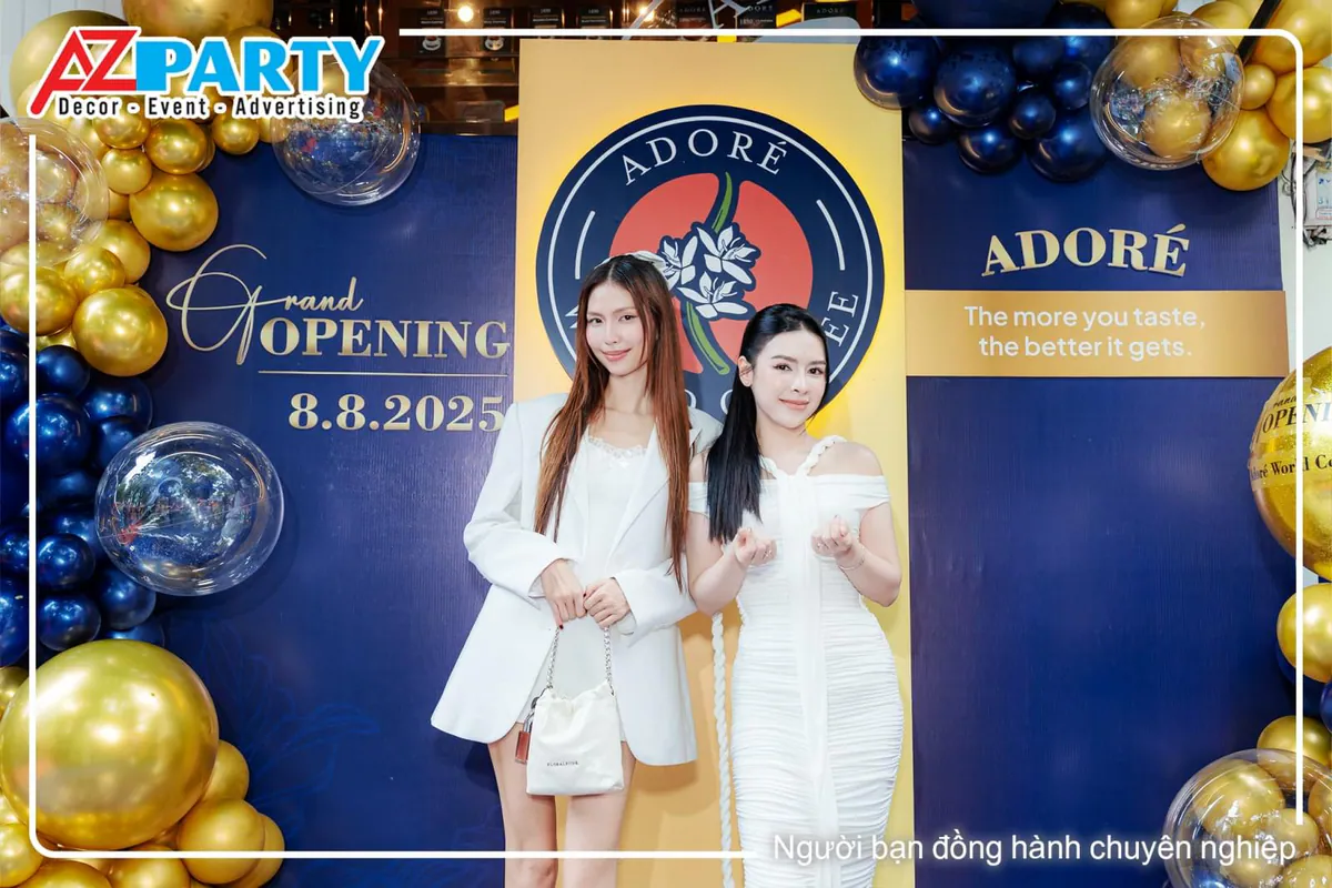 Hai nữ khách mời xinh đẹp diện đầm trắng chụp ảnh tại lễ khai trương Adore World Coffee.