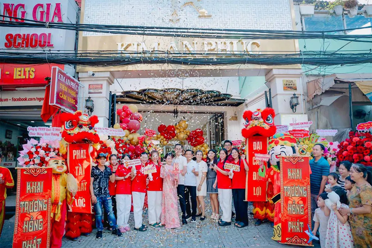 Đội ngũ nhân sự của Kim An Phúc chụp hình kỷ niệm cùng lân sự rồng, ông thần tài, ông địa ở phía trước cổng công ty