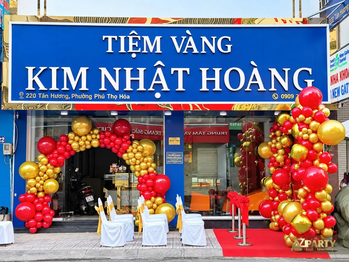 Mặt tiền tiệm vàng Kim Nhật Hoàng với cổng bóng đỏ vàng và ghế khách trắng