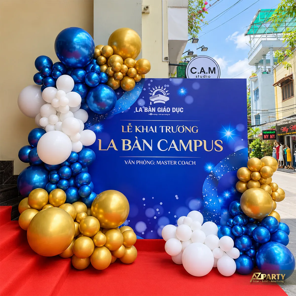 Backdrop xanh đặt cạnh bậc thang phủ thảm đỏ