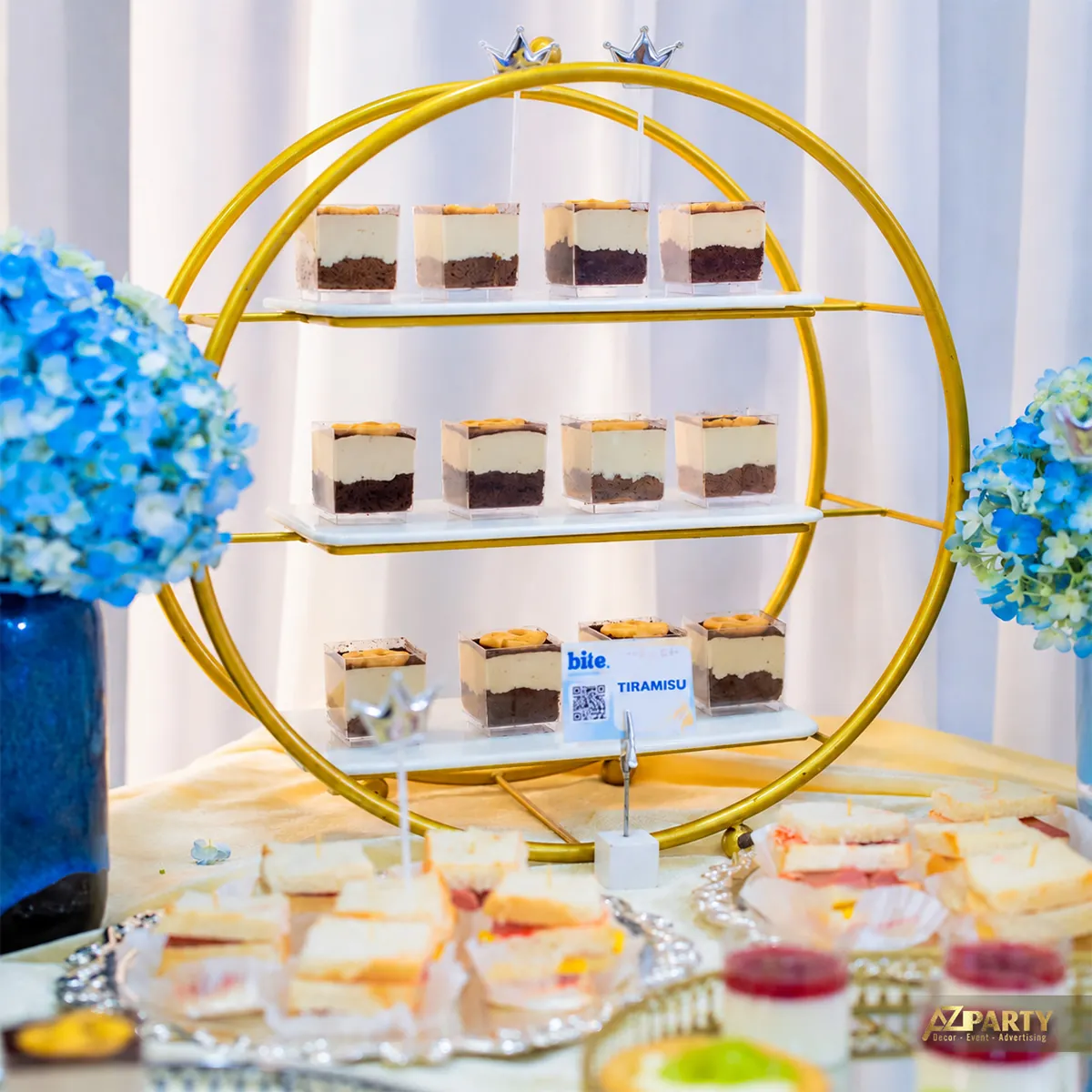 Bánh tiramisu trên kệ tròn màu vàng của bàn tiệc trà