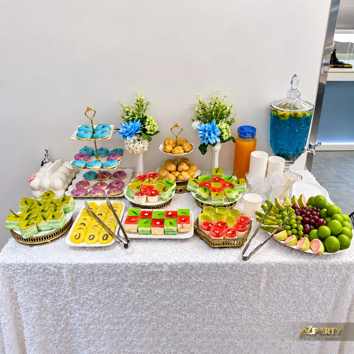 Bàn tiệc trà với bánh nhiều màu, trái cây và đồ uống