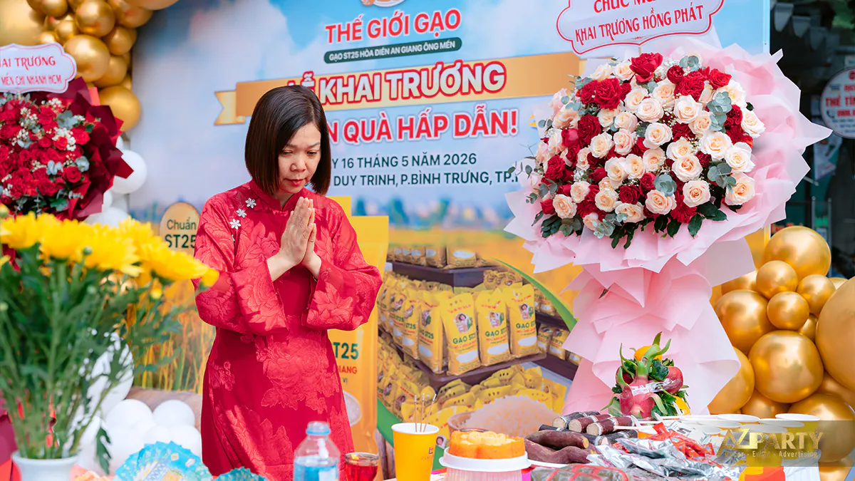 Chủ cửa hàng Thế Giới Gạo mặc áo dài đỏ thành tâm thực hiện nghi lễ cúng khai trương