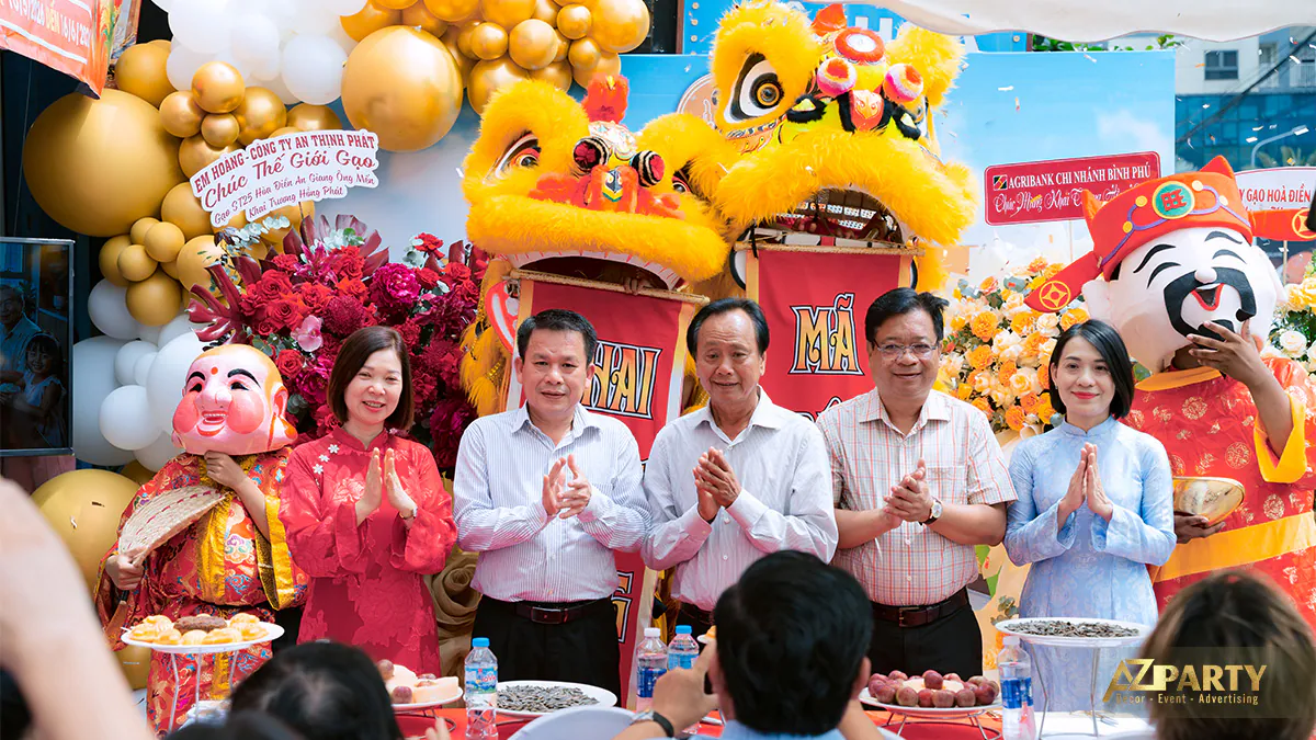 Chủ cửa hàng Thế Giới Gạo cùng khách mời và đối tác chụp ảnh lưu niệm bên đội múa lân và ông địa