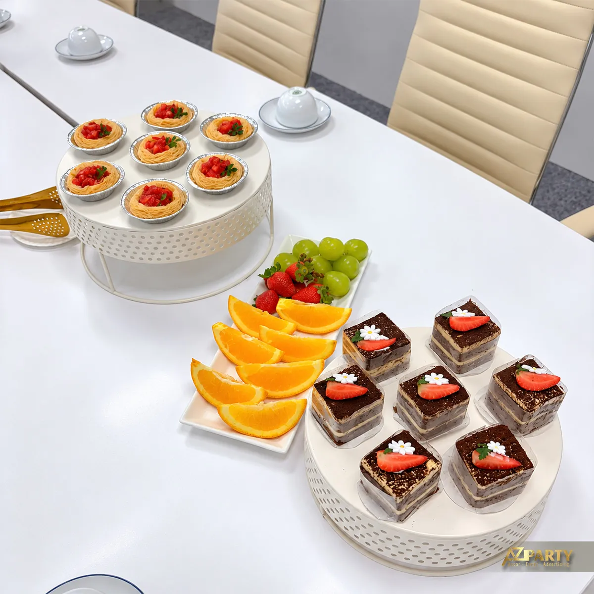 Cận bánh ngọt và trái cây trên bàn họp Dory Rich