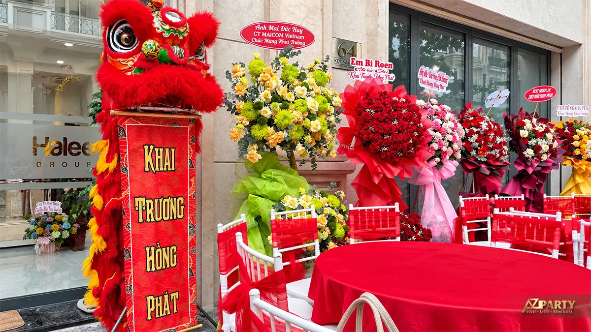 Bàn khách phủ khăn đỏ cạnh dãy hoa khai trương
