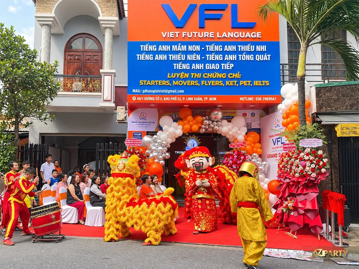 Đội lân biểu diễn trước mặt tiền trung tâm ngoại ngữ VFL với bóng cam trắng bạc