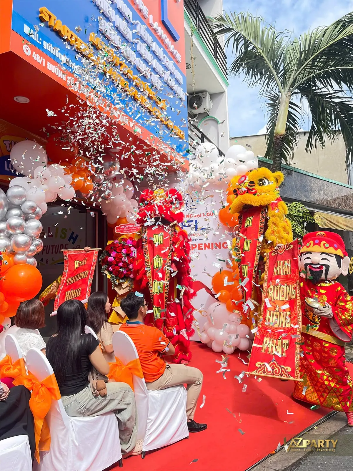 Hai chú lân giương liễn chúc mừng giữa màn giấy kim tuyến tại lễ khai trương