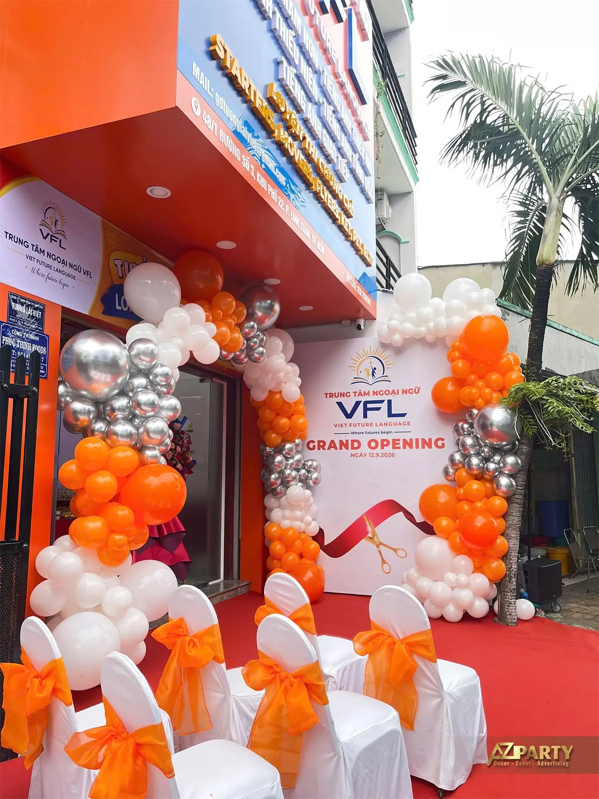 Backdrop VFL cạnh cổng bóng và hàng ghế trắng thắt nơ cam