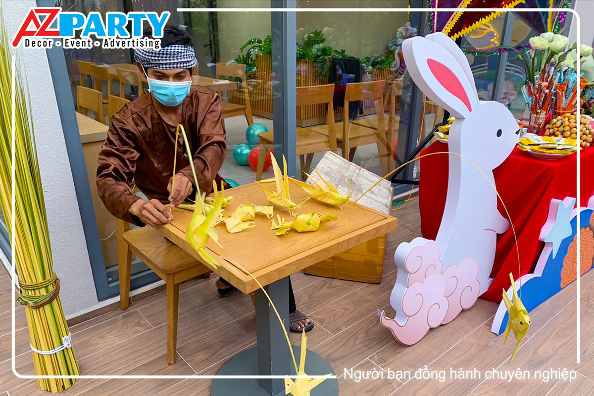 Nghệ nhân đang tỉ mỉ tạo hình châu chấu từ lá dừa để tặng cho các bé tại trung thu Waterpoint.