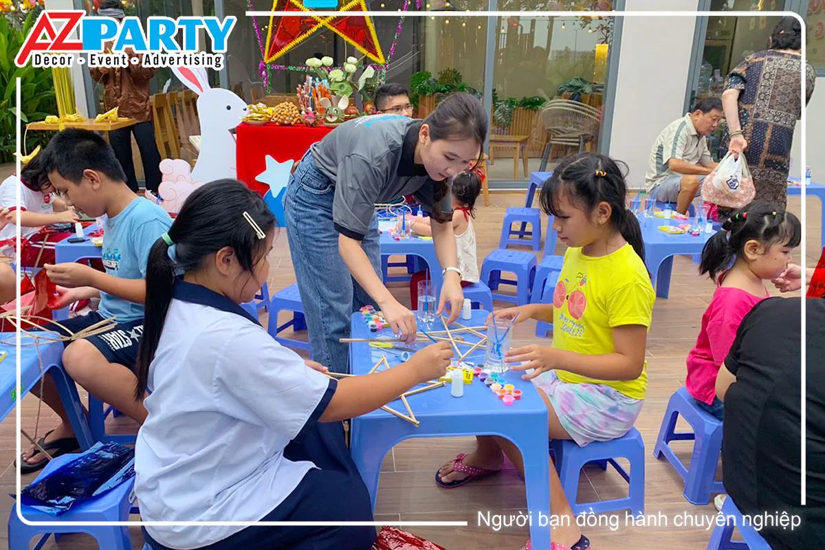 Nhân viên hỗ trợ tận tình hướng dẫn hai bé gái tự tay lắp ráp và làm lồng đèn ông sao trung thu.