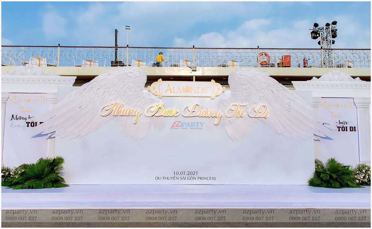 Cận cảnh chi tiết đôi cánh thiên thần 3D nổi bật trên phông nền trắng của photo booth kỷ niệm Almonds.