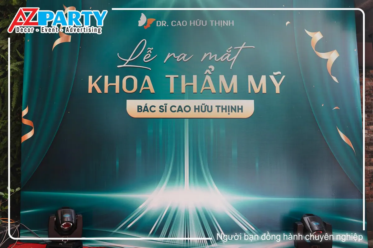 Backdrop lễ ra mắt Khoa Thẩm Mỹ Bác sĩ Cao Hữu Thịnh thiết kế tông màu xanh teal hiện đại.
