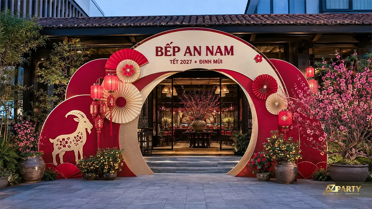 Cổng vào nhà hàng Bếp An Nam trang trí vòng cung đỏ kem, đèn lồng, hoa đào và cây quất
