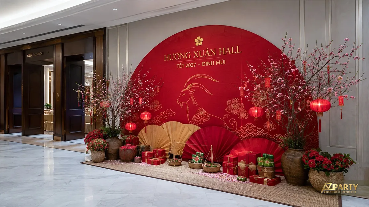 Backdrop Tết tại Hướng Xuân Hall với vòng tròn đỏ, dê vàng, cành đào, quạt giấy và hộp quà