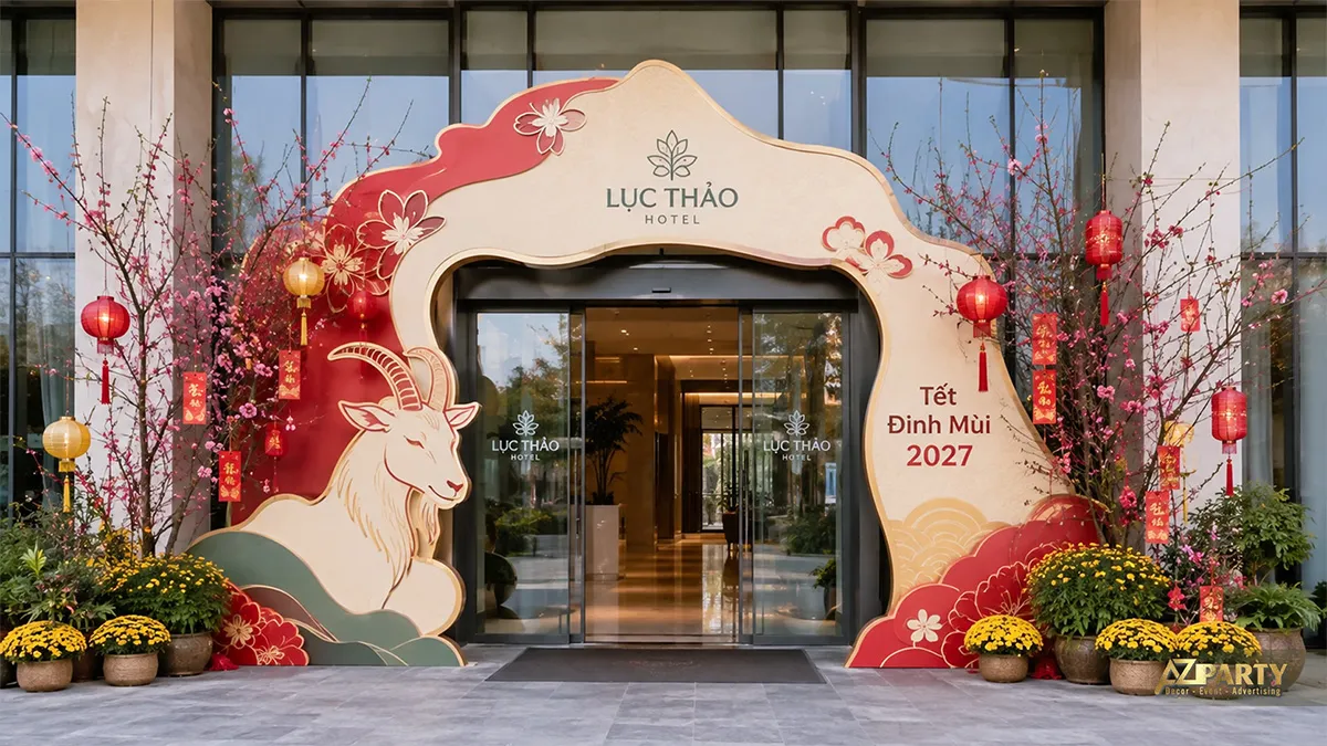 Mặt tiền Lục Thảo Hotel với cổng vòm đỏ kem, linh vật dê, hoa đào và cúc vàng
