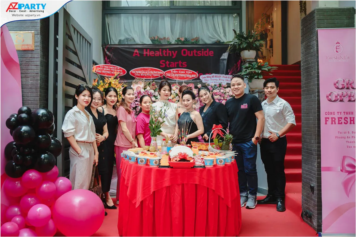 Đội ngũ sáng lập và nhân viên Fresh & Fit chụp hình bên mâm cúng khai trương trước cửa văn phòng