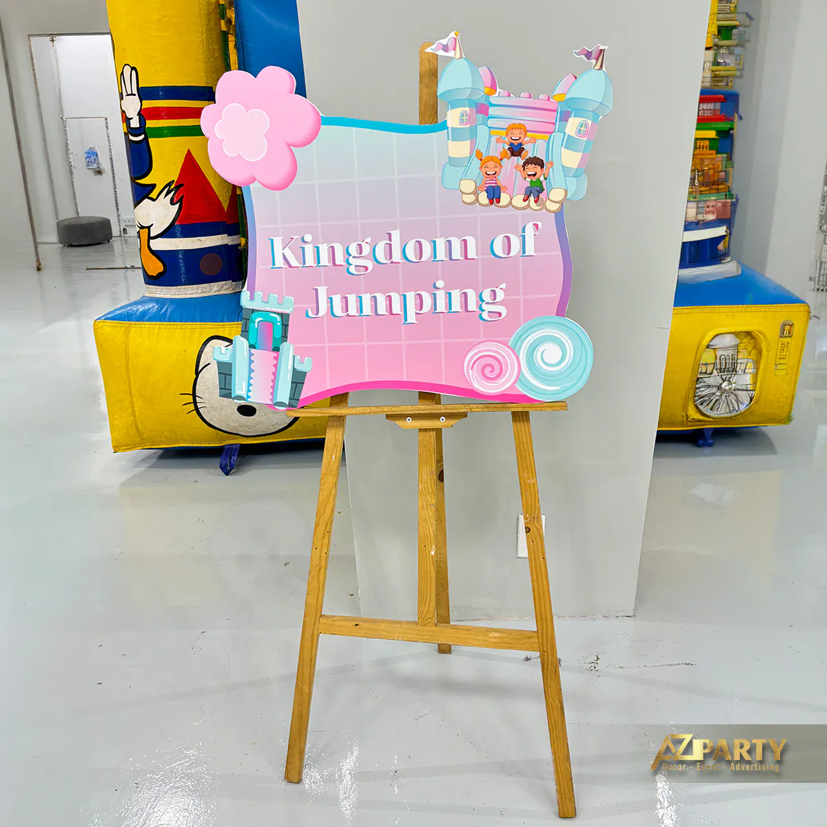Biển hướng dẫn Kingdom of Jumping với nhà hơi phía sau tại ngày hội gia đình ASW Family Day