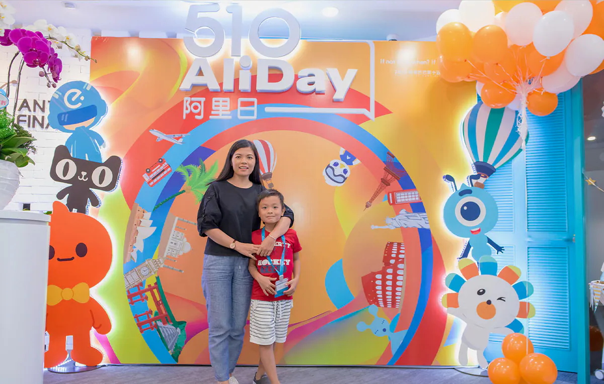 Mẹ và con trai chụp hình lưu niệm trước backdrop rực rỡ sắc màu tại sự kiện ngày hội gia đình Aliday.