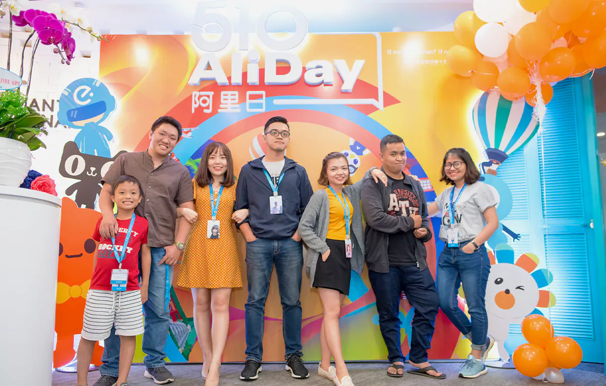 Tập thể nhóm nhân viên chụp ảnh lưu niệm vui vẻ trước backdrop 510 AliDay.
