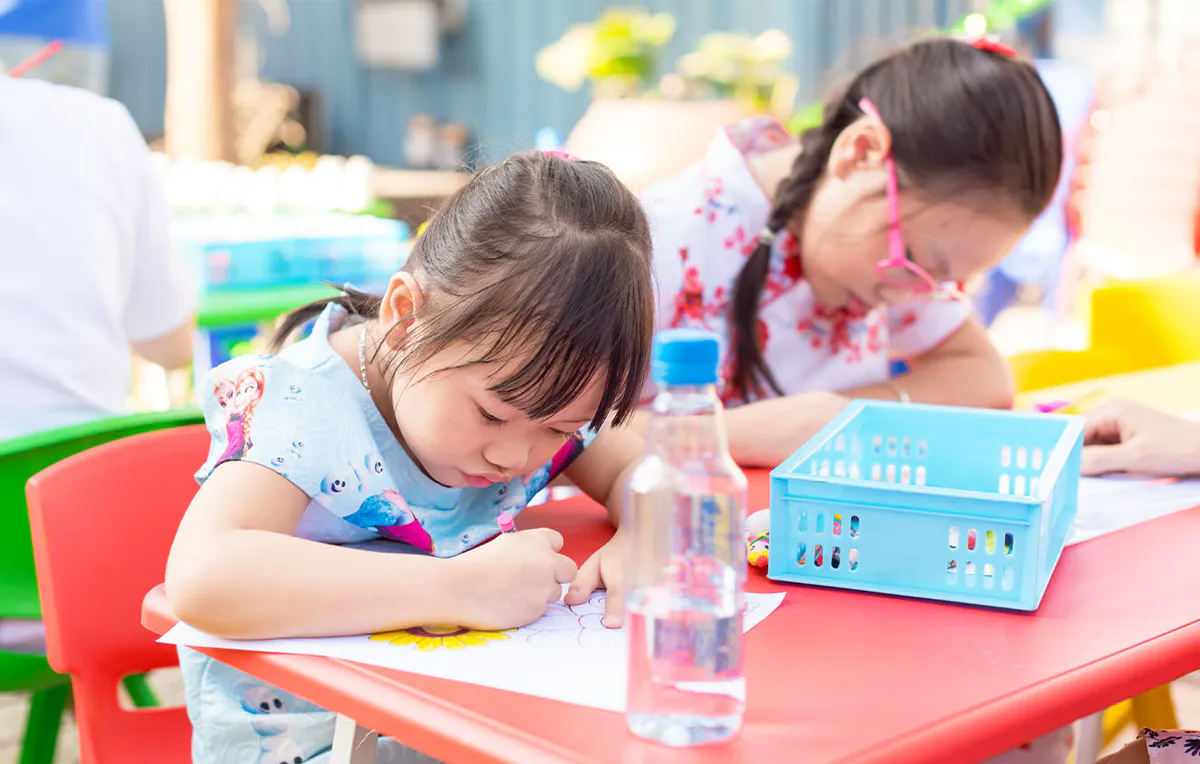 Các bé gái đang chăm chú và nỗ lực vẽ tranh, tô màu tại bàn mỹ thuật dành riêng cho trẻ em trong sự kiện Ngày hội gia đình.