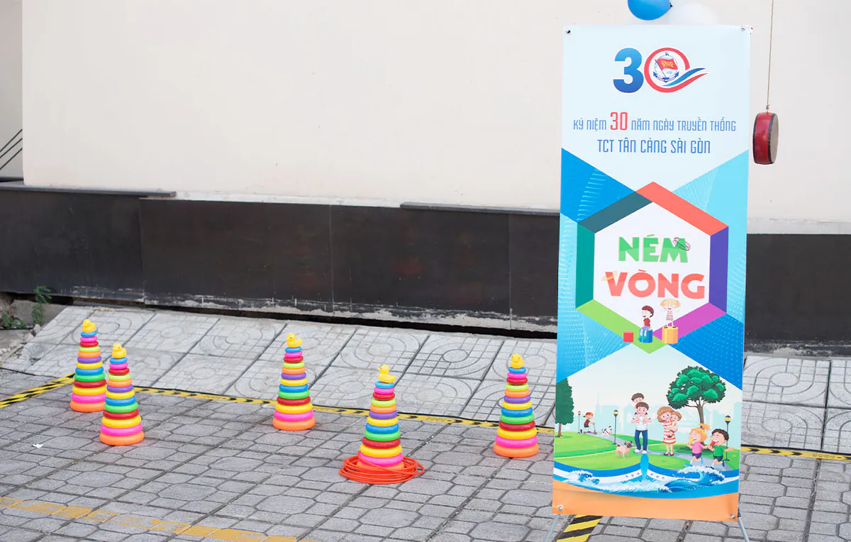 Khu vực trò chơi ném vòng được bố trí khoa học với standee hướng dẫn trò chơi Ném vòng cùng các cọc ném hình tháp nhựa nhiều màu sắc ngoài trời.