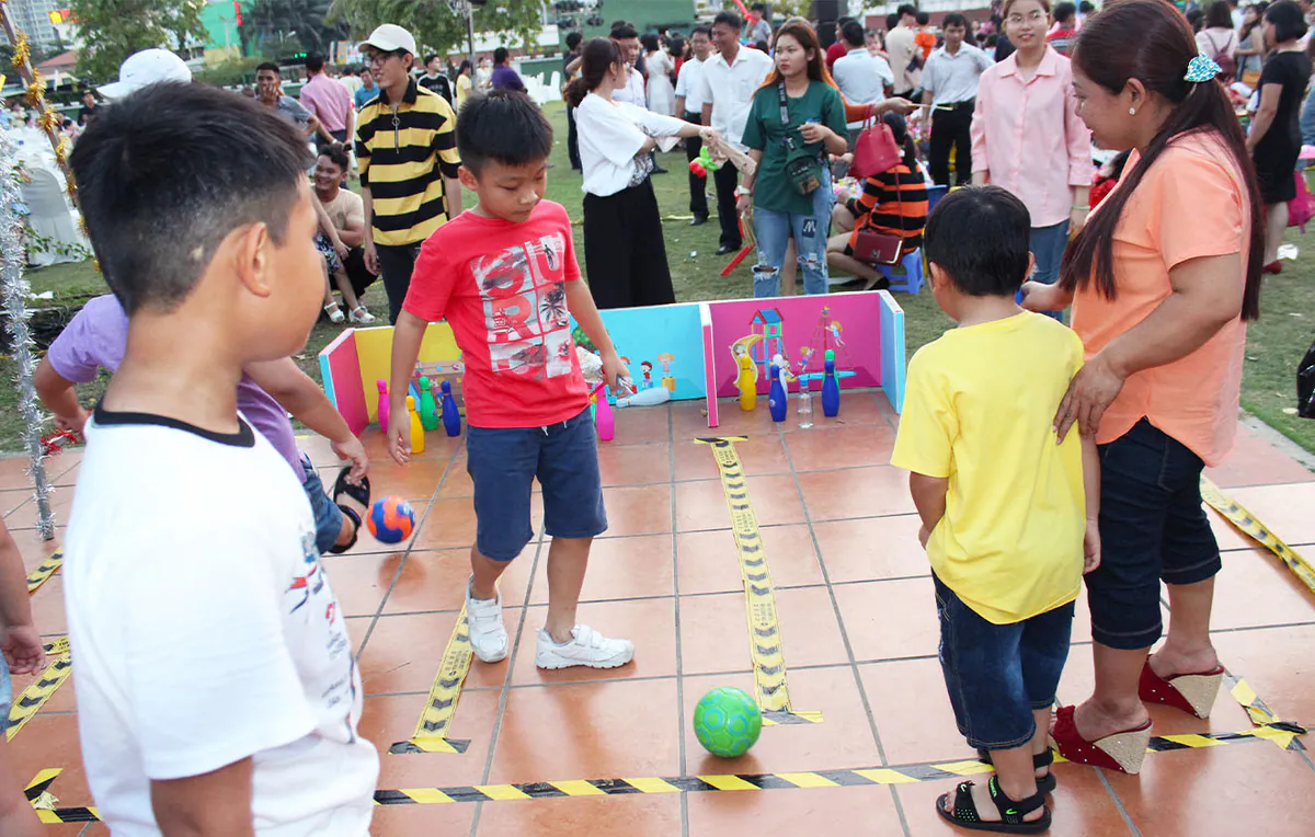 Gian hàng trò chơi bowling mini dành cho các bé trải nghiệm lăn bóng nhựa đổ các quân pin màu sắc trong ngày hội.