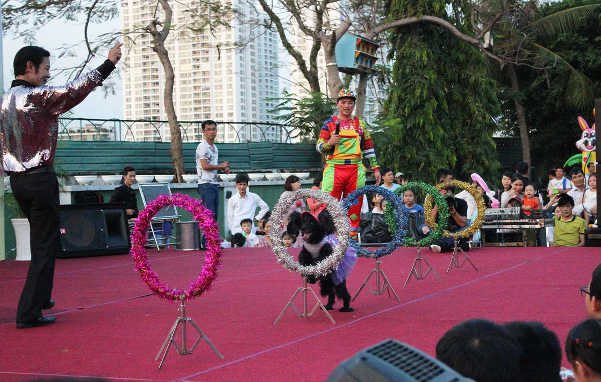Tiết mục xiếc chó nhảy qua vòng tròn lấp lánh trên sân khấu sự kiện kỷ niệm 30 năm Tân Cảng Sài Gòn.