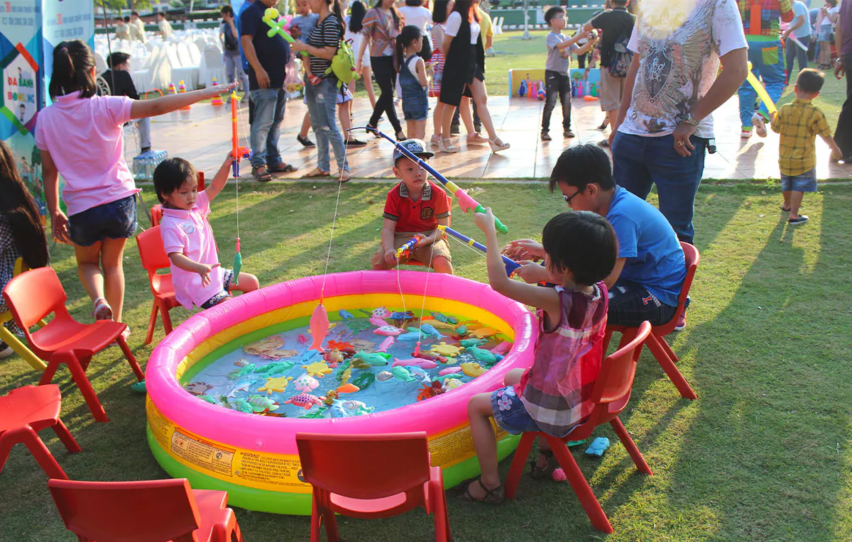 Không khí nhộn nhịp, tươi vui tại khu vực trò chơi câu cá ngoài trời dành cho các bé thiếu nhi tham gia ngày hội gia đình.