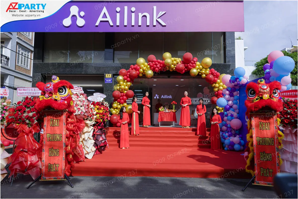 Đội ngũ PG xinh đẹp trong trang phục áo dài đỏ chào khách tại sự kiện khai trương công ty Ailink Bình Thạnh