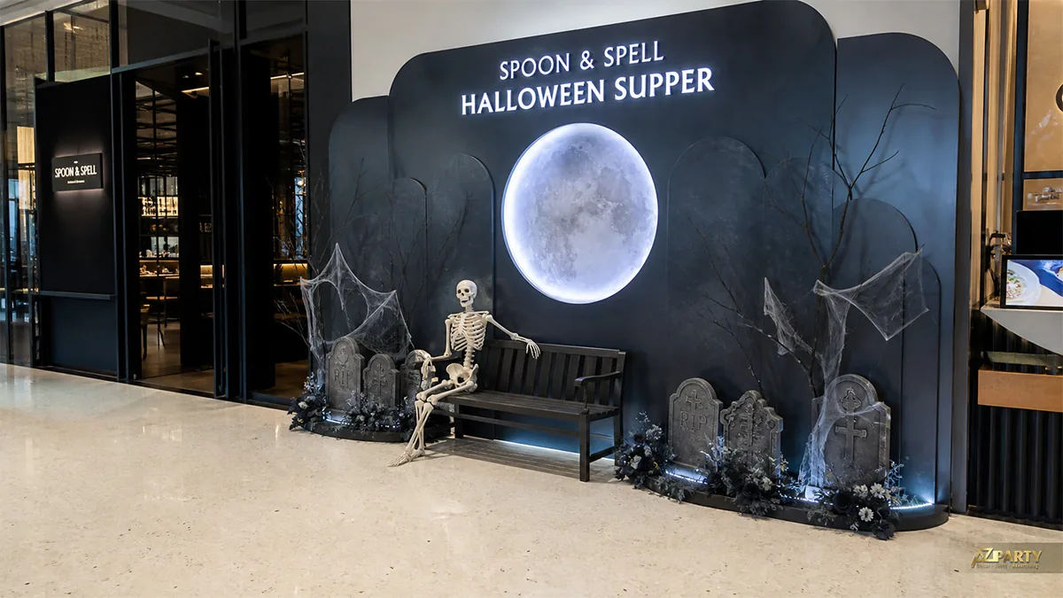 Photobooth Halloween với trăng tròn, bộ xương ngồi ghế và cụm bia mộ