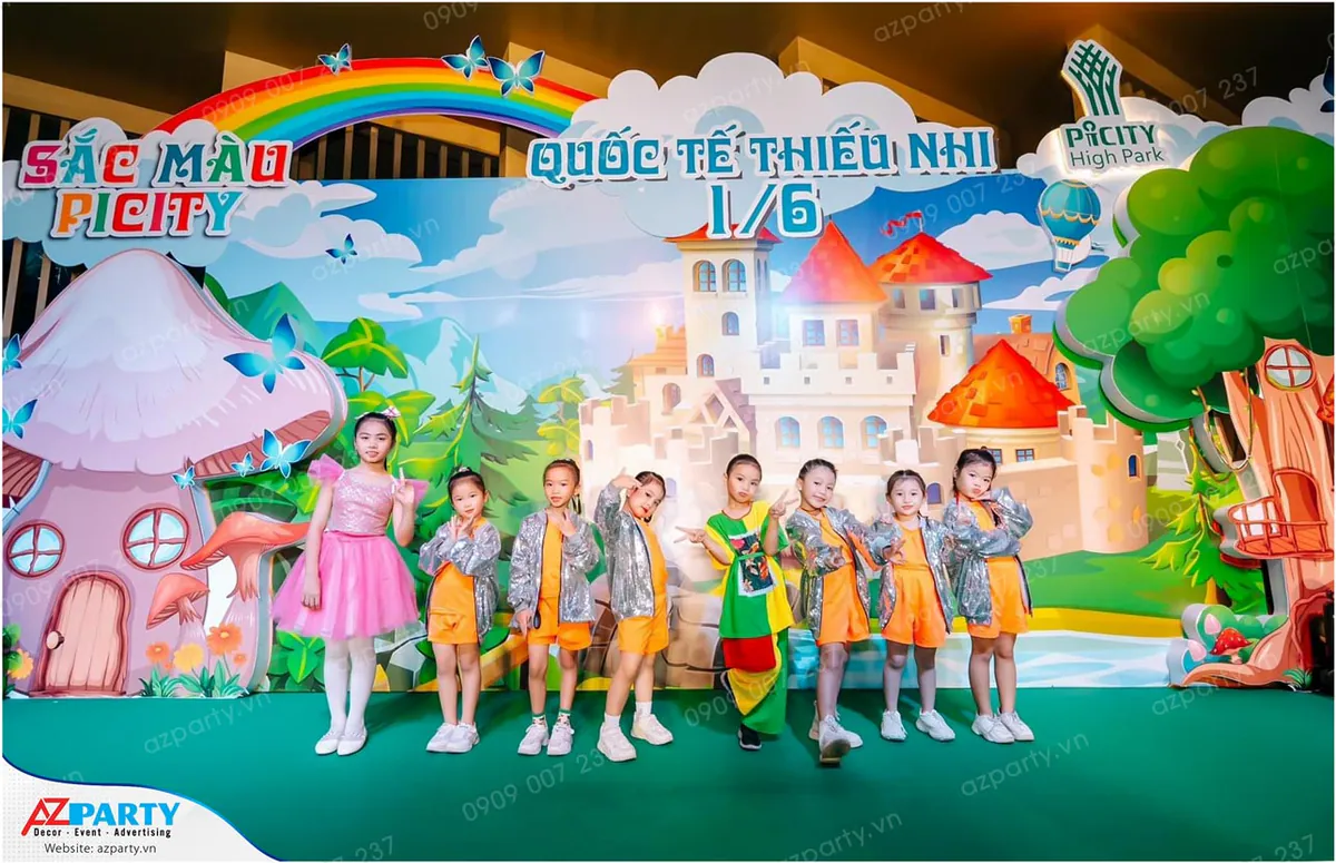Nhóm múa thiếu nhi trong trang phục biểu diễn màu cam lấp lánh xếp hàng tạo dáng chụp ảnh kỷ niệm trên sân khấu Quốc tế Thiếu nhi 1/6 Picity