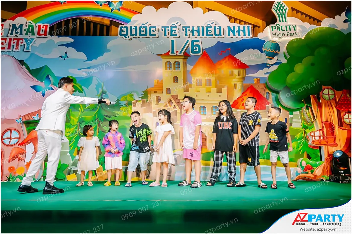 MC nam phỏng vấn giao mic cho một bé trai hào hứng phát biểu trong trò chơi đố vui trên sân khấu ngày hội thiếu nhi 1/6 Picity