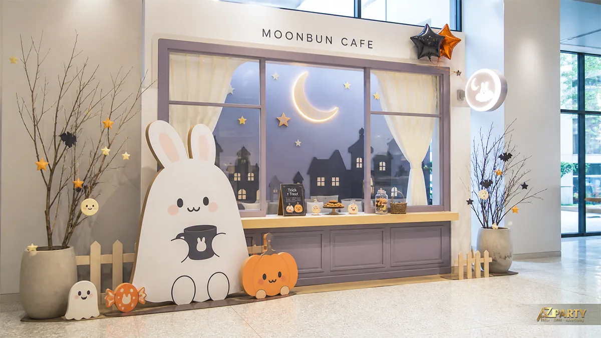 Quầy cà phê Halloween với thỏ trắng, trăng sáng, bí ngô và khung cửa phố đêm