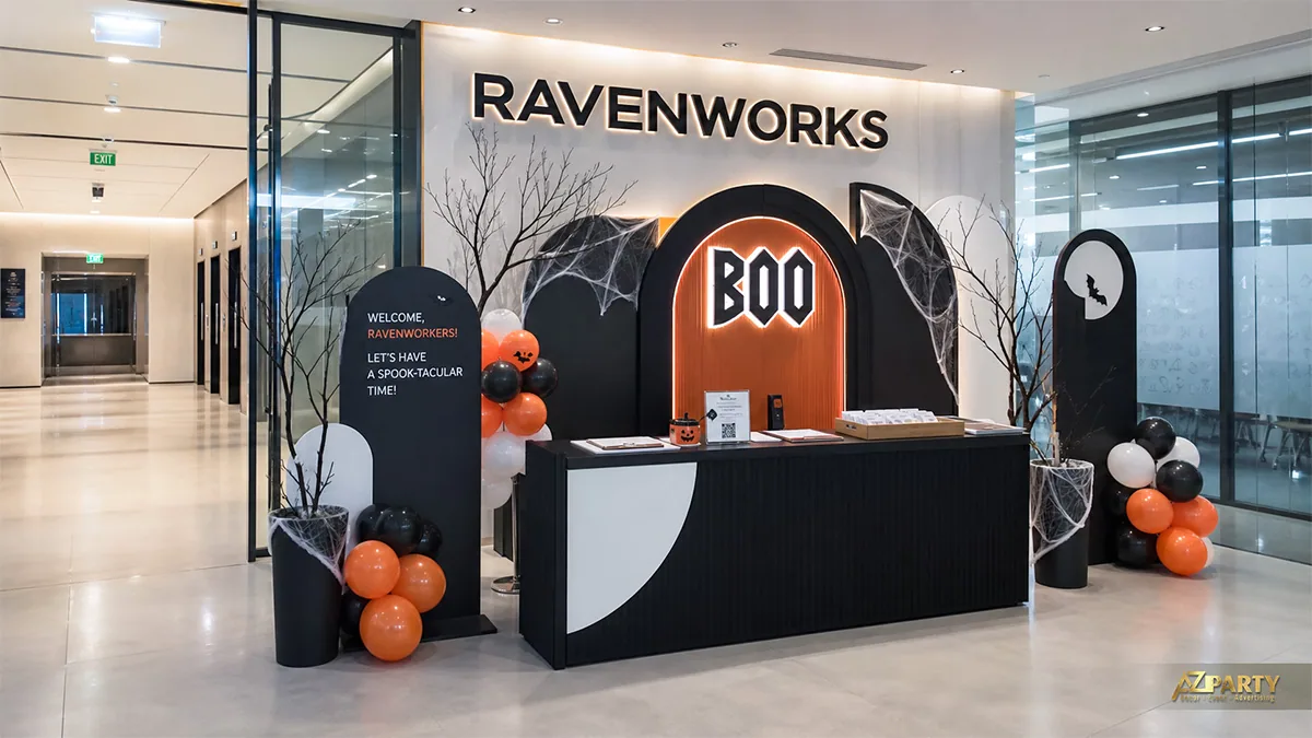Quầy đón khách công ty Halloween tông đen trắng với chữ Boo, bóng cam và mạng nhện