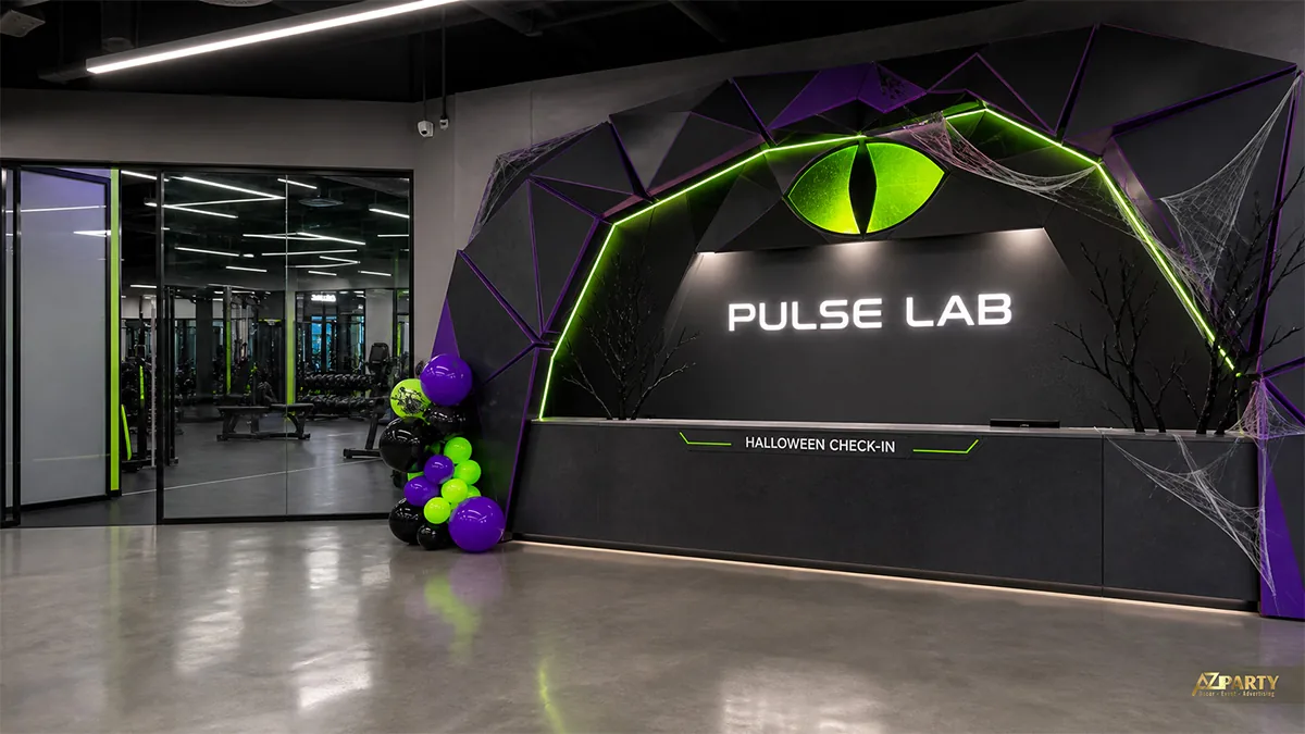 Quầy lễ tân phòng gym với vòm mắt mèo xanh, bóng bay và mạng nhện