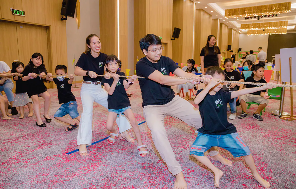 Hoạt động kéo co kịch tính giữa các gia đình, các bé cùng bố mẹ đang dồn hết sức lực để kéo sợi dây thừng về phía mình.