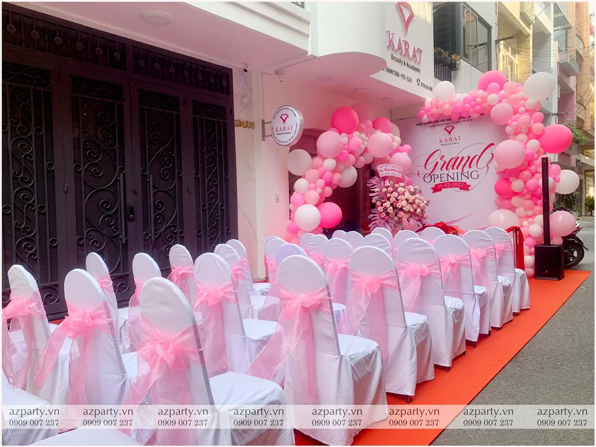 Không gian chuẩn bị đón khách tại lễ khai trương Karat Spa với hàng ghế nơ hồng và backdrop bong bóng.