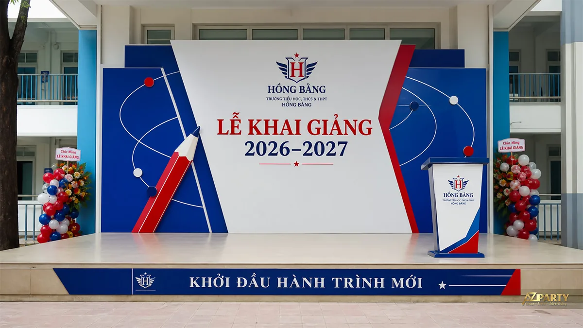 Sân khấu khai giảng Hồng Bàng màu xanh đỏ với bút chì lớn và bục phát biểu đồng bộ