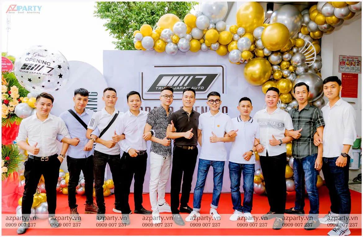 Khách mời nam chụp ảnh kỷ niệm trước backdrop khai trương showroom ô tô Trung Japan Auto